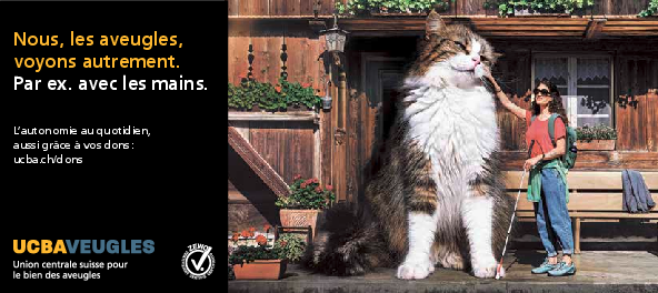 Une femme munie d'une canne blanche caresse un chat gigantesque devant une ferme de l'Emmental.